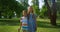 Two smiling siblings posing with rackets. Playful children hugging in park.