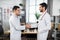 Two smiling skilled Arab doctors at the clinic giving a handshake to each other