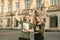 Two smiling students friends with happy emotions raising hands up outdoors at university. Proud cheerful students with broad