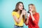 Two smiling students girls drinking morning coffee, inhale the aroma of coffee. Pleasure, relaxation, happiness