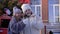 Two smiling teen girl holding burning sparklers on winter street on decorative New Year tree background. Happy young