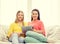 Two smiling teenage girls with tablet pc at home