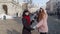 Two smiling women lesbian LGBT tourists walking together on city street, family couple embracing