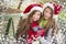 Two Smiling Women Santa Hats Holding a Wrapped Gif