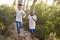 Two smiling young boys racing on a forest path