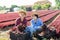 Two smiling young female workmates showing red lettuce harvest on field