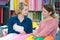 Two smiling young women selecting fabric