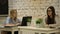 Two smilling businesswomen working on laptop at office