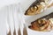 Two smoked Baltic herring and a metal fork on a white background. Close-up. Macro
