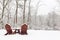 Two snow-covered chairs in the backyard.