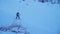 Two snowboarders descend down the snow-covered slope in the forest