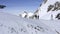 Two snowboarders on edge snowy slope while ski touring winter resort drone view