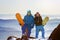 Two snowboarders stands on the top of mountain