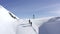 Two snowboarders walking in snowshoes for climbing on snowy mountain aerial view