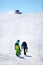 Two snowboarders walking up a slope