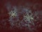 Two snowflakes glittering on dark textured background