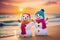 Two snowman on the ocean sandy beach.Tropical Christmas or New Year holidays concept.