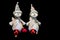 Two snowmen figurines with red baubles on black