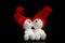 Two snowmen in red knitted caps, isolate on a black background.