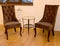 Two soft chairs and coffee table stand at a wall in a drawing room