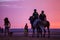 Two spanish police officers patrolling beach at sunset on horseback