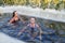 two sporting beautiful young women swimming in an ice hole in a winter sunny day