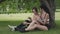 Two sports girls rest after training in the park. Young women sitting on the grass under a tree