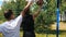 Two sportsmen playing basketball on the court outdoors, one sportsman dribbling and missing past the basket