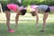 Two sporty females warming up on lawn in park