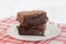 Two stacked chocolate fudge walnut brownies on a plate.  Shallow focus