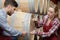 two staff inspecting barrels in wine factory warehouse