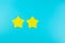 Two star yellow paper note on blue background with copy space for text. Customer reviews, feedback, rating, ranking and service