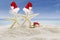 Two starfishes with Santa hats at beach