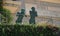 Two Statues standing on balcony leaning against handrails.