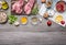 Two steaks with oil and spices on cutting board with lemon, salt and meat fork, sliced mushrooms, napkin border ,with text area o