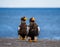Two Steller`s sea eagles are sitting on a concrete pier against the background of the sea.