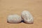 Two stone pebbles with the word beach and anchor sign over sandy beach