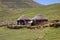 Two stone rondavels with traditional thatched roofs.