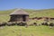 Two stone rondavels with traditional thatched roofs.