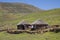 Two stone rondavels with traditional thatched roofs.