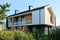 Two storey cottage with balcony and group of windows