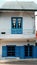 Two storey house in light color wall, blue paint wooden window and door at Da Lat