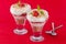 Two strawberry and cream desserts on red background