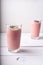 Two strawberry raspberry smoothies with hemp seed and cocoa bean topping