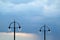 Two street lamps against sky background