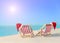 Two striped sunloungers with Christmas Santa hats at ocean sunset beach