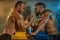 Two strong athletes in the gym compete in arm wrestling. Bodybuilders armwreslers in athletic training room