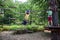 Two strong excited young friends playing outdoors in rope park. Caucasian boys dressed in casual clothes and sneakers at warm