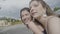 Two students girls traveling by car going on vacation playing leaned out of the window having fun and feeling free and happy -