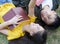 Two students reading book on grass